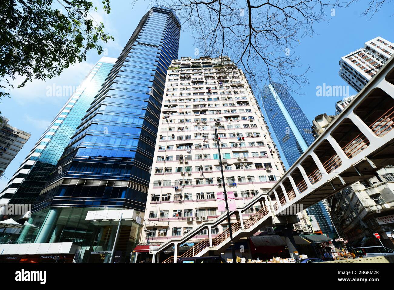 Vecchio edificio residenziale lungo i moderni grattacieli nella baia di HongKong. Foto Stock