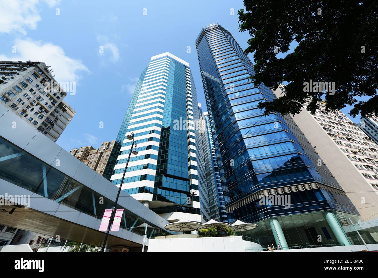 Vecchio edificio residenziale lungo i moderni grattacieli nella baia di HongKong. Foto Stock