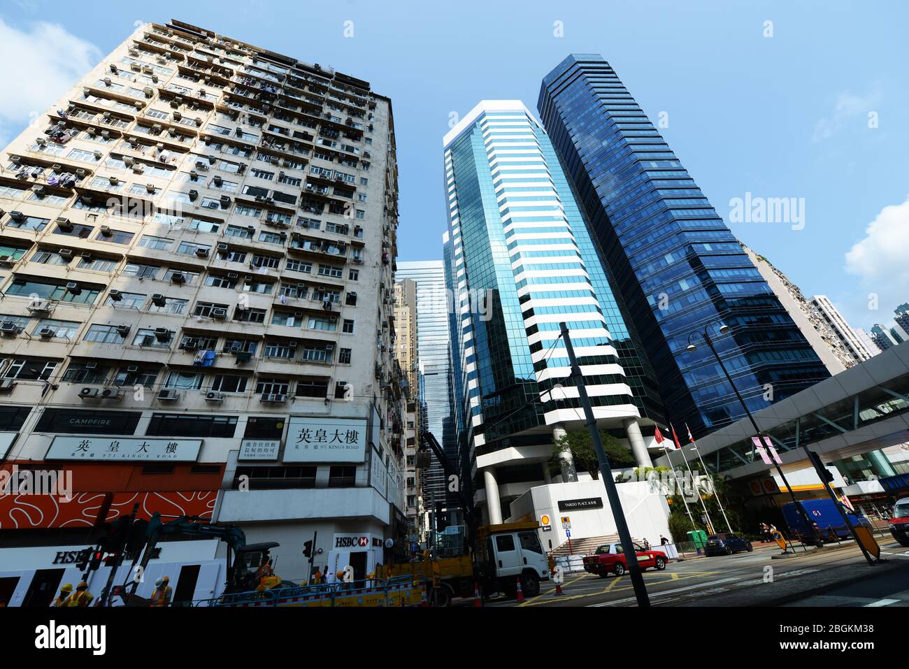 Vecchio edificio residenziale lungo i moderni grattacieli nella baia di HongKong. Foto Stock