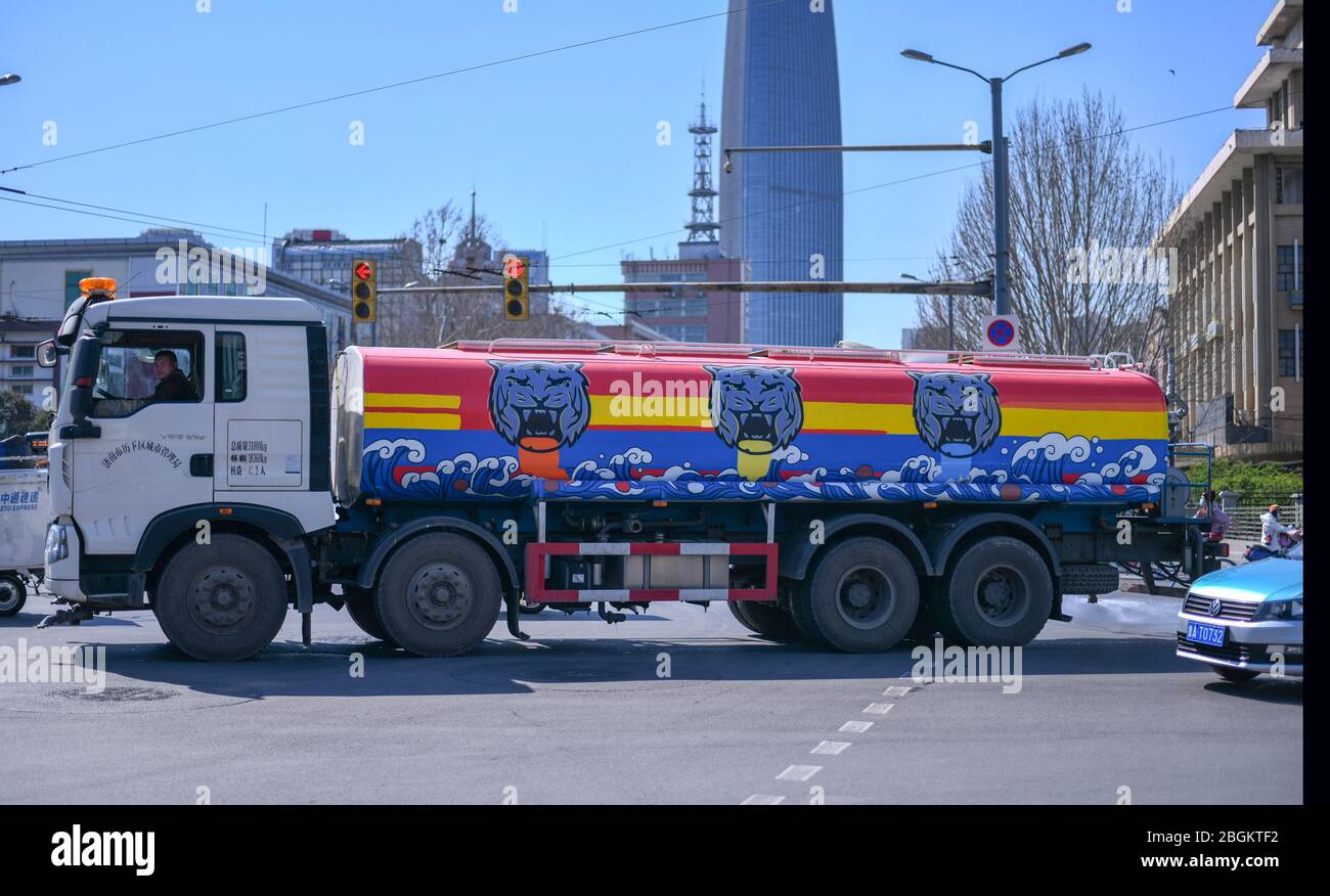 Un camion di irrigazione, che è dipinto con tre tigri, che implica l'attrazione turistica locale della Black Tiger Spring, lavora per idratare la strada, Jinan Foto Stock