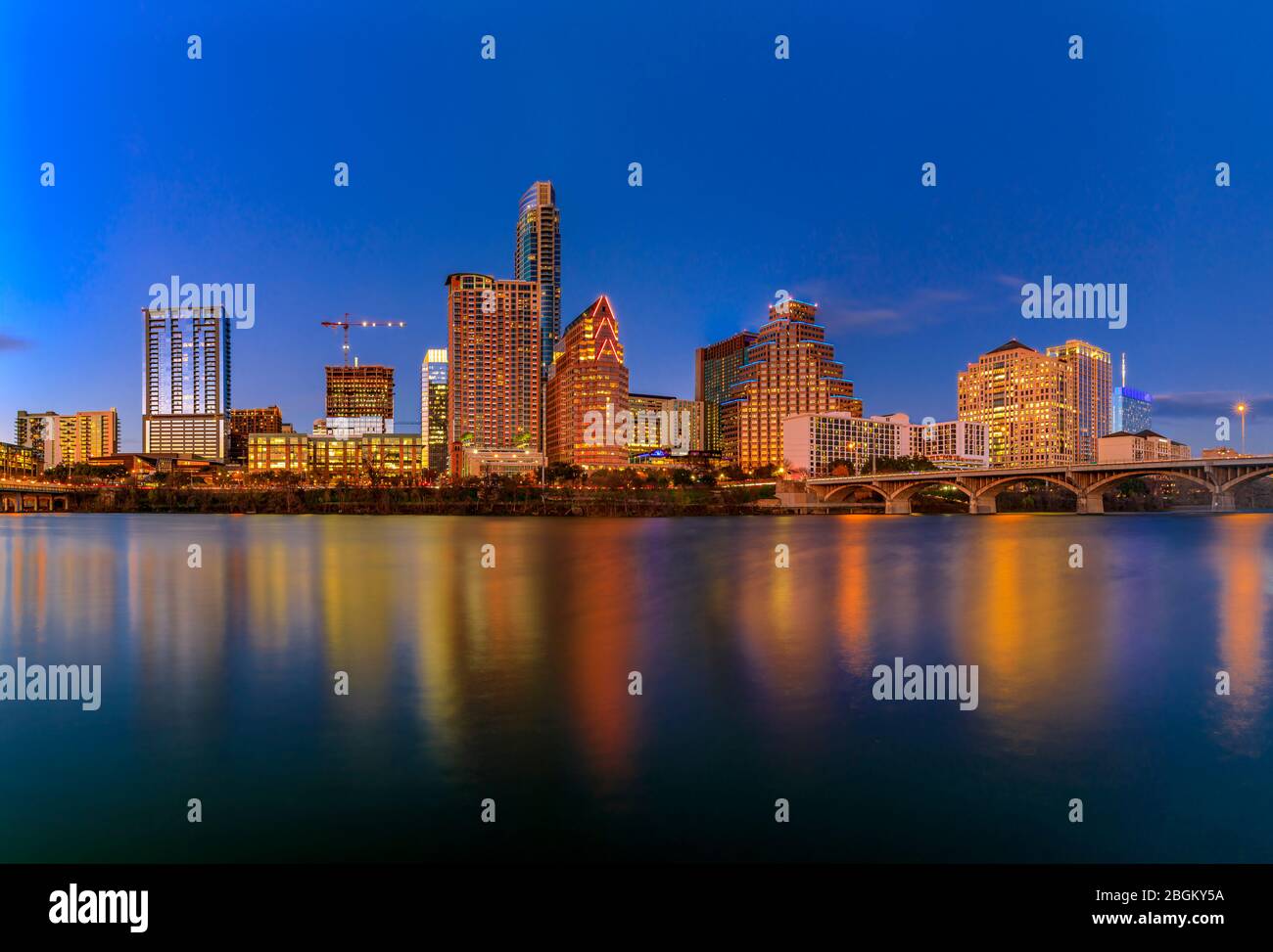 Gli alti alti alti alti alti alti del centro riflettono il tramonto e la luce dorata, vista sul Lady Bird Lake o sul Town Lake sul fiume Colorado ad Austin, Texas, Stati Uniti Foto Stock