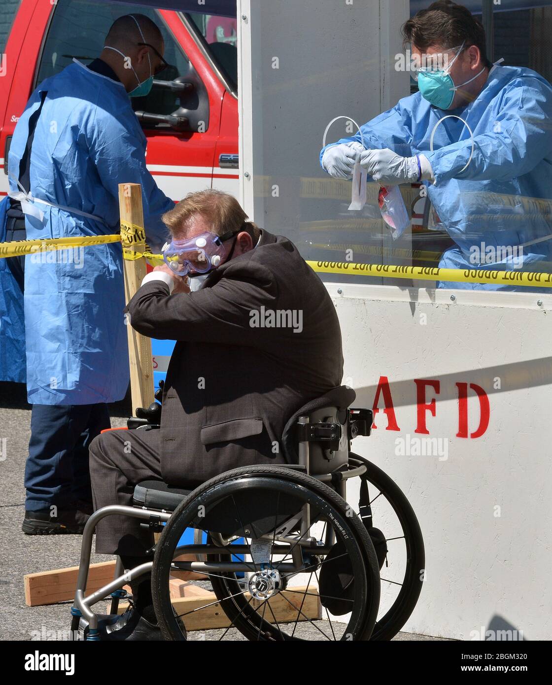 Andy Bales, CEO della missione di salvataggio, tosse nel braccio prima di amministrare un kit di auto-test COVID-19 presso una stazione di test a comparsa DEL Dipartimento DI LA Fire, Dove i lavoratori in abiti hazmat hanno consegnato i tamponi di prova ai senzatetto da dietro una finestra di protezione nella sezione Skid Row di Los Angeles il martedì 21 aprile 2020. Altre quarantatre persone hanno dato prova di positivo per il coronavirus alla Union Rescue Mission, il più antico e più grande rifugio senza tetto di Los Angeles. L’improvviso picco dei casi arriva nonostante le precauzioni estreme che il riparo sta prendendo per prevenire un simile focolaio. Foto Foto Stock