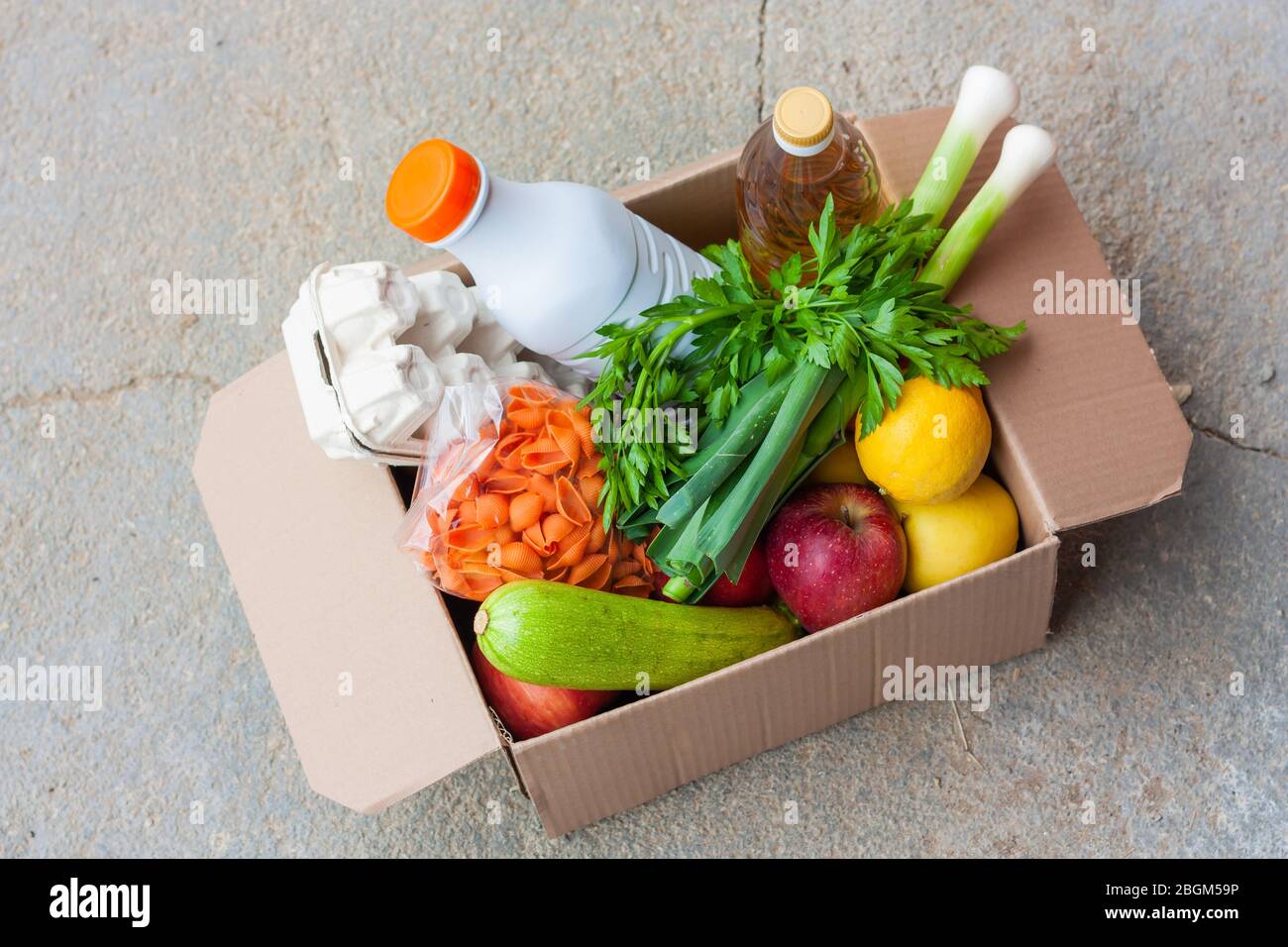 Consegna durante la quarantena o concetto di donazione di cibo. Scatola con verdure, frutta e cibo. Assistenza in fase di quarantena Foto Stock