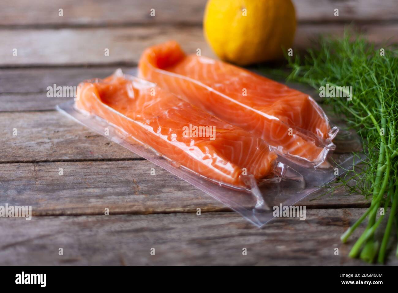 Filetti di pesce rosso o salmone su tavola di legno. Pesce fresco, limone e aneto per cucinare gli ingredienti. Omega-3. Messa a fuoco selettiva Foto Stock