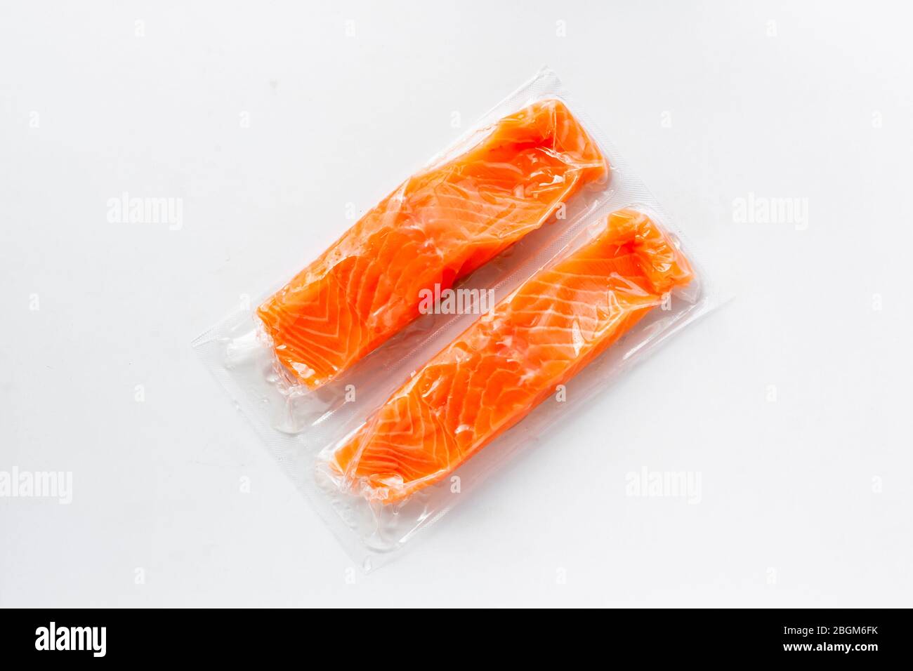 Filetti di pesce rosso o salmone in confezione sottovuoto su fondo bianco. Pesce fresco, omega 3. Concetto di alimentazione sana. Foto Stock