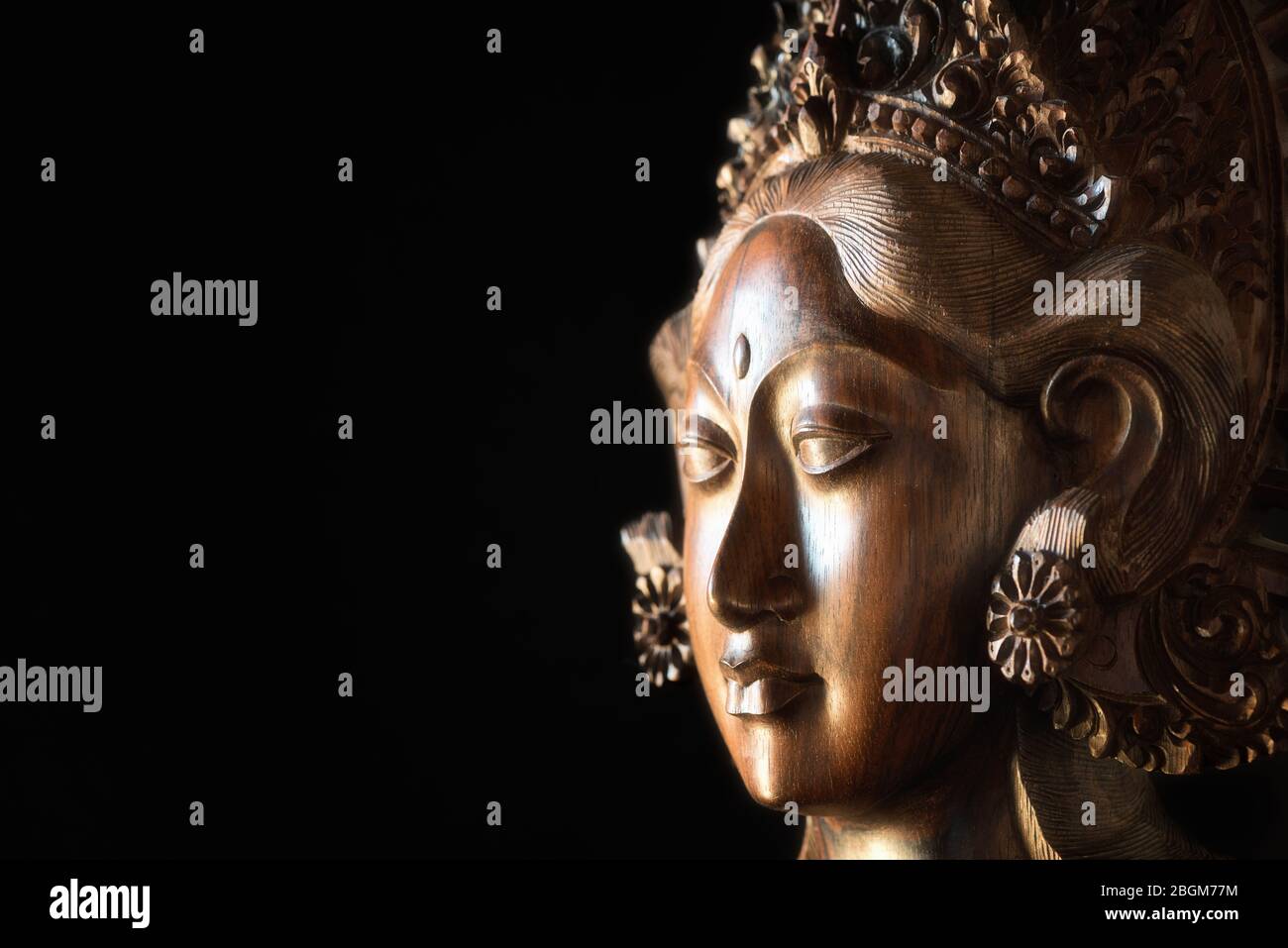 Testa femmina in legno intagliato. Parvati Face, dea indù della fertilità, dell'amore, della bellezza, del matrimonio, dei bambini e della devozione. Artigianato balinese. Foto Stock