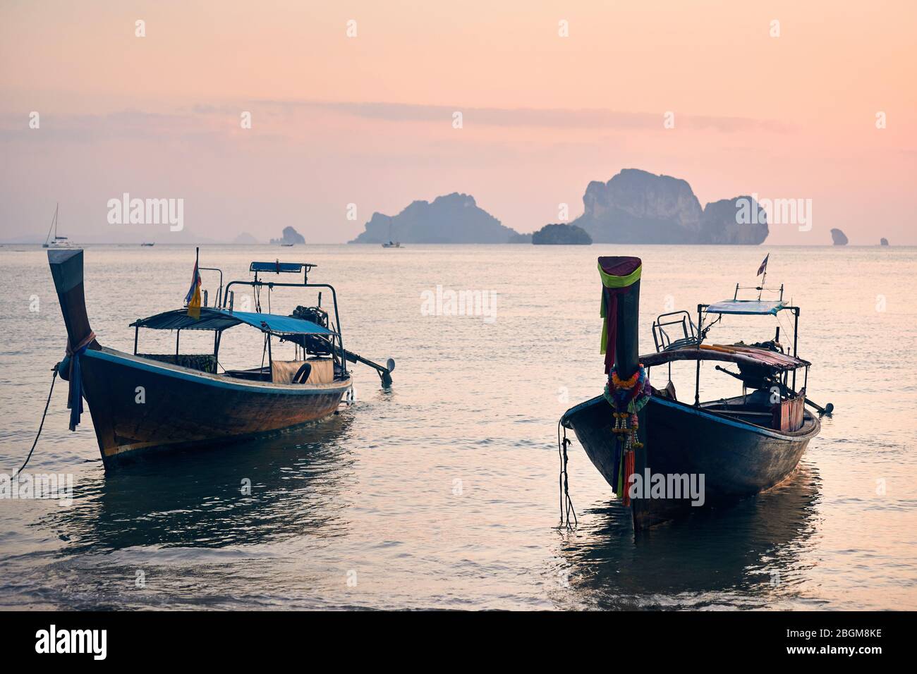 Tradizionale lunga coda sulla spiaggia tropicale al tramonto a sfondo delle isole nel mare delle Andamane, Thailandia Foto Stock