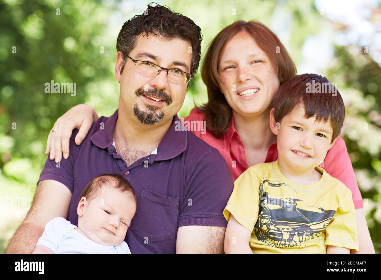 Glückliches Ritratto mit Vater, Mutter, kind und Baby im Grünen Foto Stock