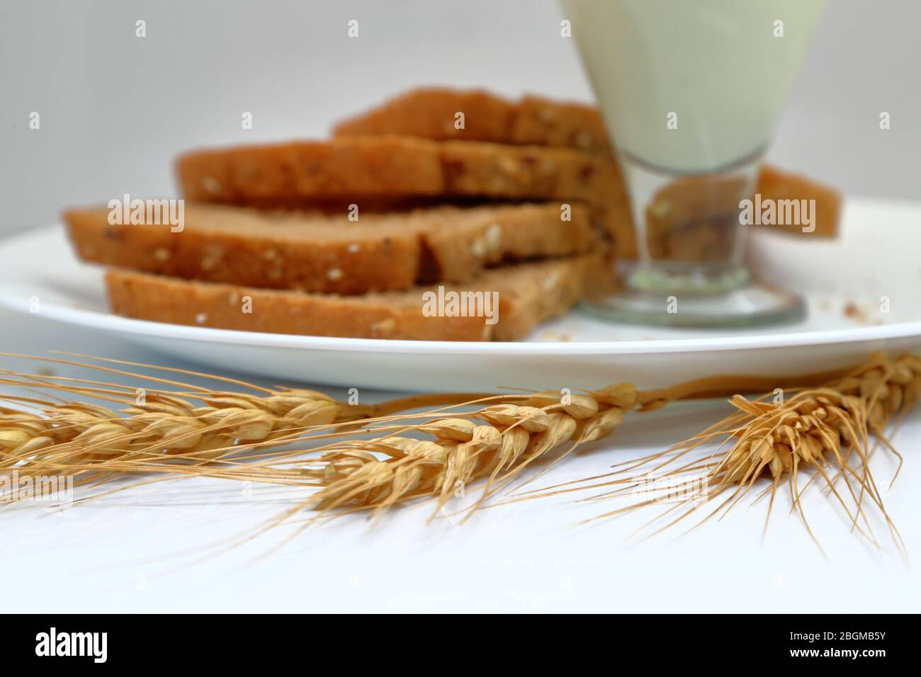 Pane fresco con bicchiere di latte in un piatto di ceramica. Foto Stock