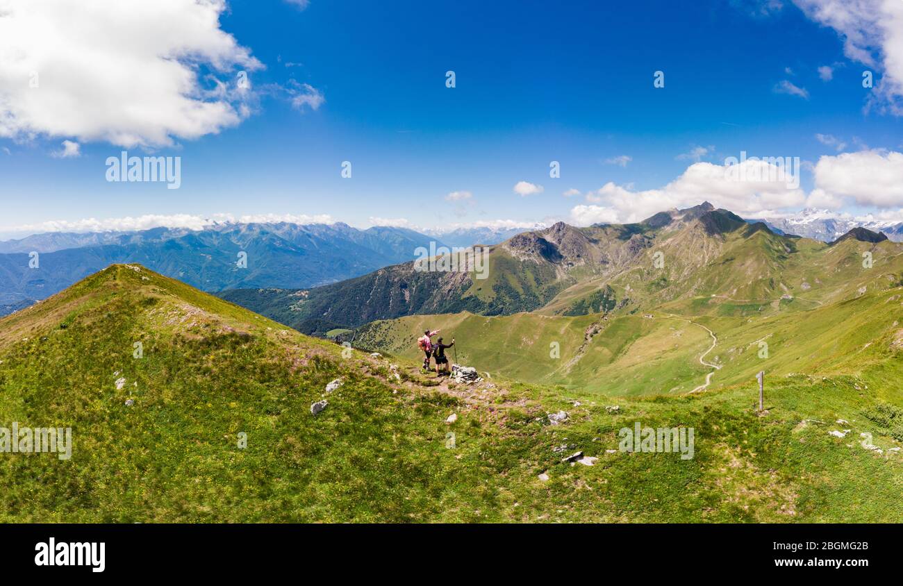 Aereo: Coppia backpackers escursioni in cima alla montagna, paesaggio panoramico. Avventure estive sulle Alpi. Conquista il successo adulto maturo avendo wellbei divertimento Foto Stock