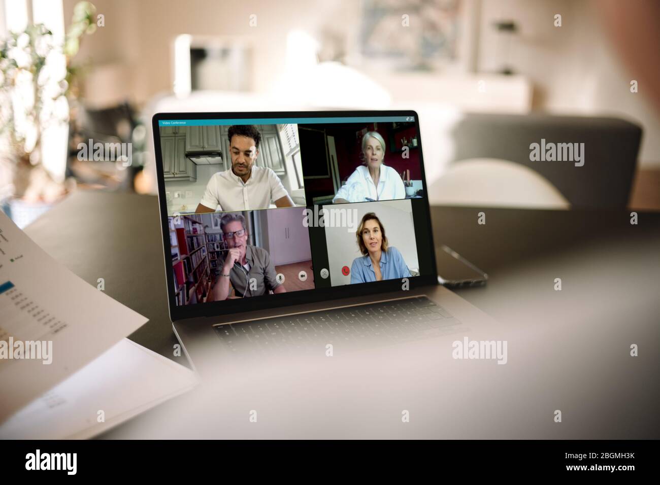 uomini d'affari che hanno una riunione online. Un gruppo di uomini e donne in videoconferenza su un laptop. Foto Stock