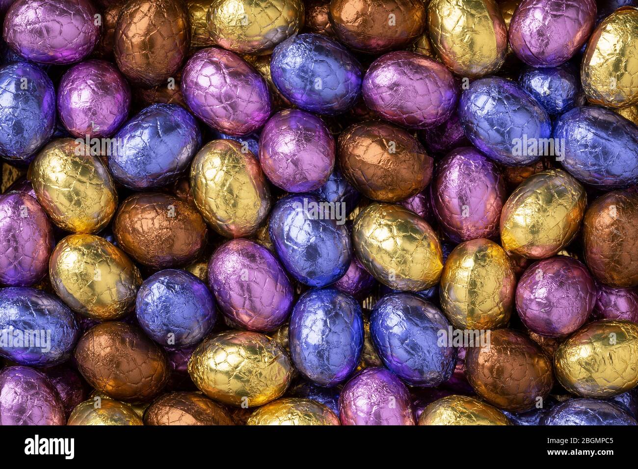 Uova di pasqua al cioccolato in coloratissimo tinfoil primo piano su cornice intera Foto Stock