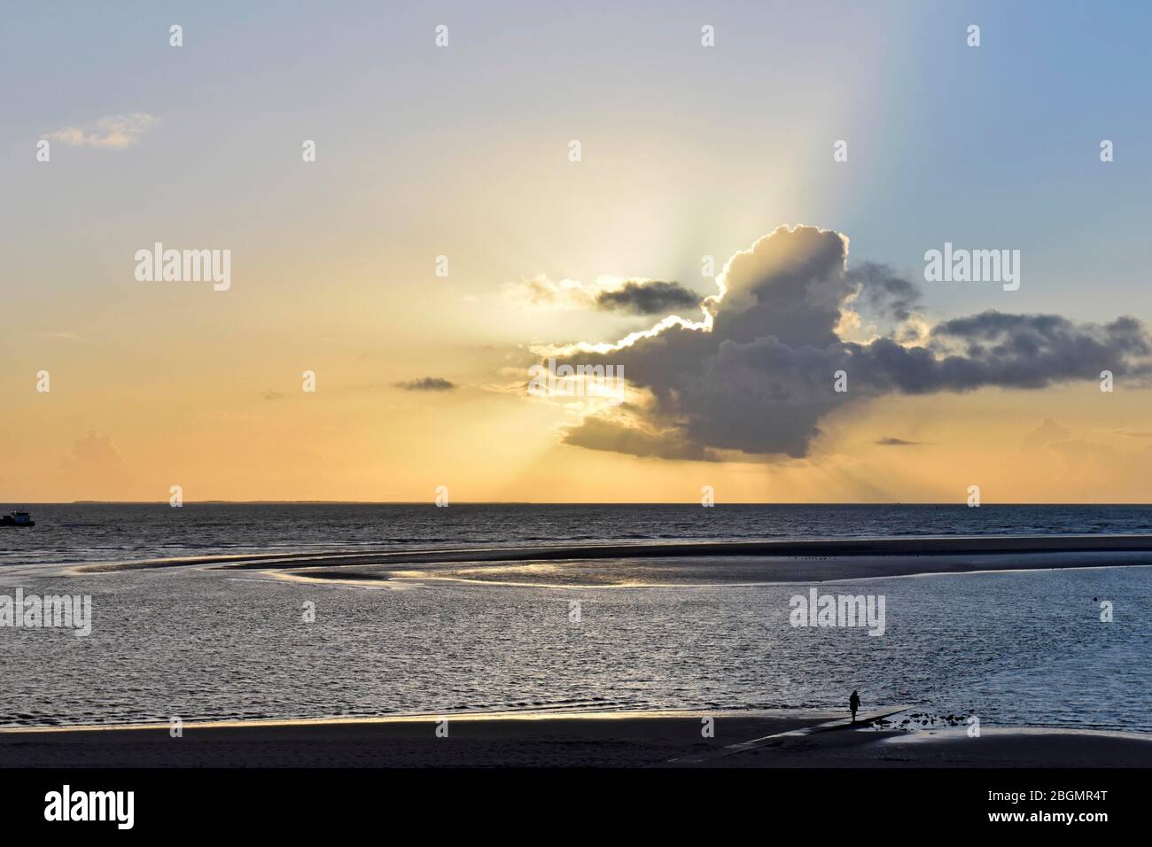Tramonto dietro nuvola sul Mare del Nord e la spiaggia, Borkum, Frisia Est, bassa Sassonia, Germania Foto Stock