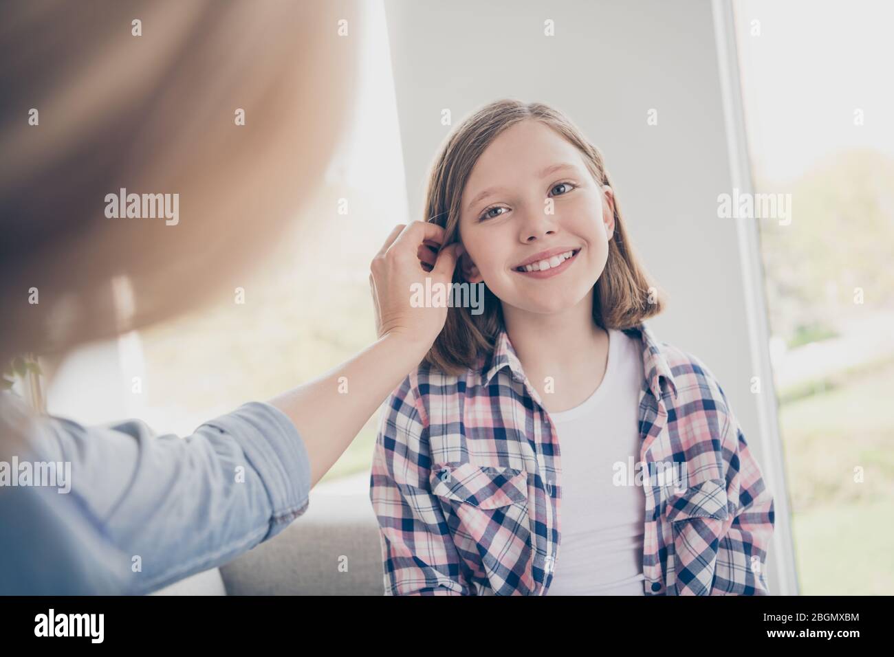 Foto di casa affascinante bionda signora mamma figlia rilassante comodo divano soggiorno casa buon umore quarantena tempo trascorrere insieme soggiorno Foto Stock