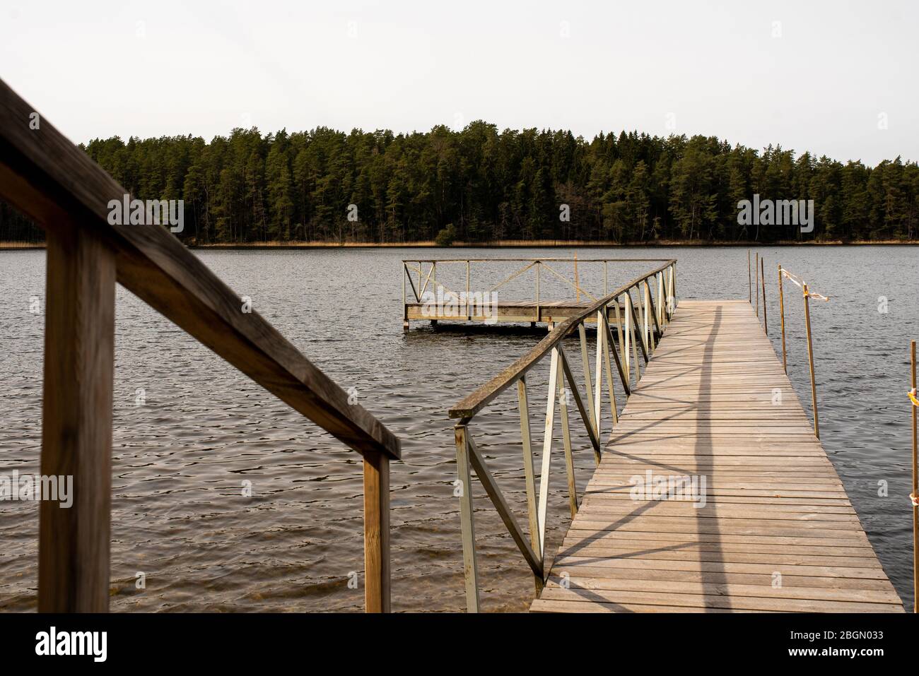 Lago tranquillo nella foresta con un molo, con il tempo nuvoloso. Foto Stock