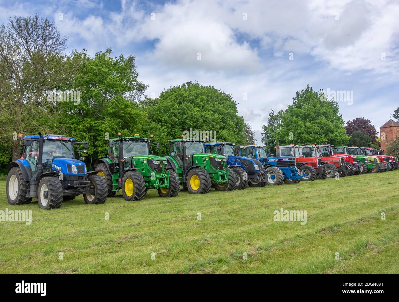 Pocklington, Yorkshire, Regno Unito, 05/24/2015 - una linea di trattori multicolore parcheggiati in un campo. Foto Stock