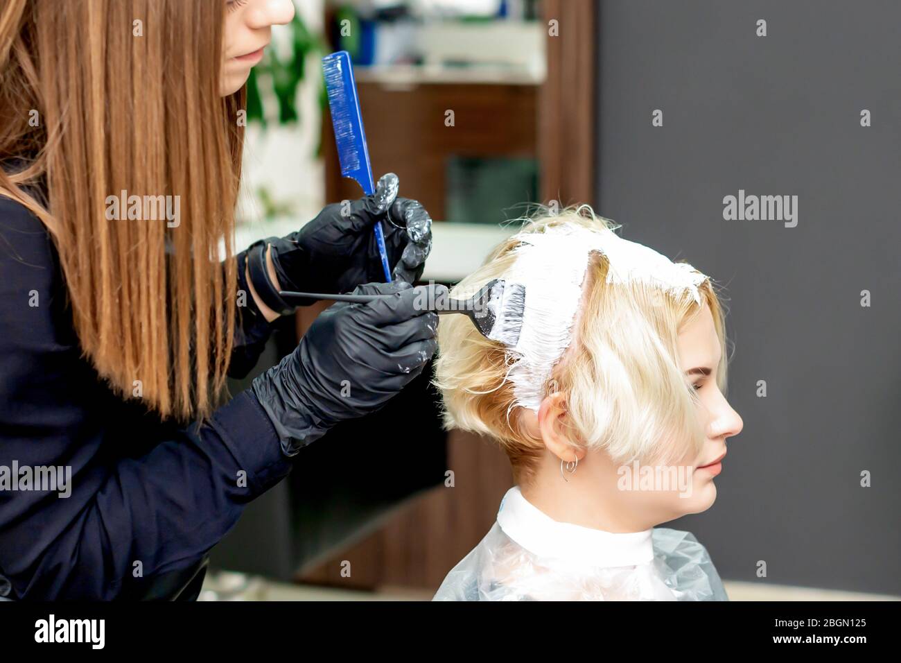 Il parrucchiere tinge i capelli di donna in tinta bianca nel salone di  bellezza Foto stock - Alamy
