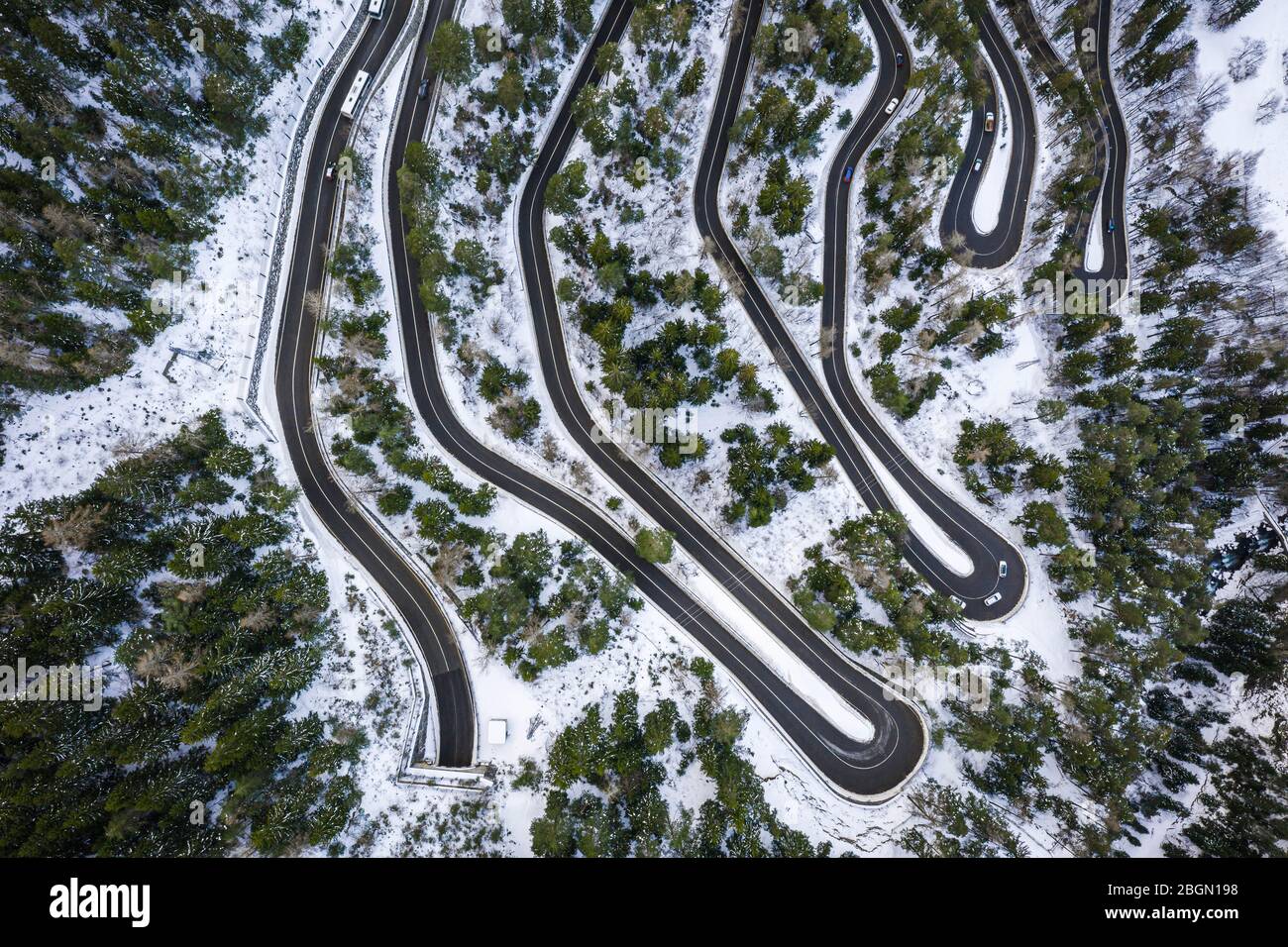 Vista aerea di una serpentina di automobile su una montagna. Strada per il villaggio di la Thuile e la zona sciistica. Serpentina di montagna innevata in Valle d'Aosta in Italia. Foto Stock
