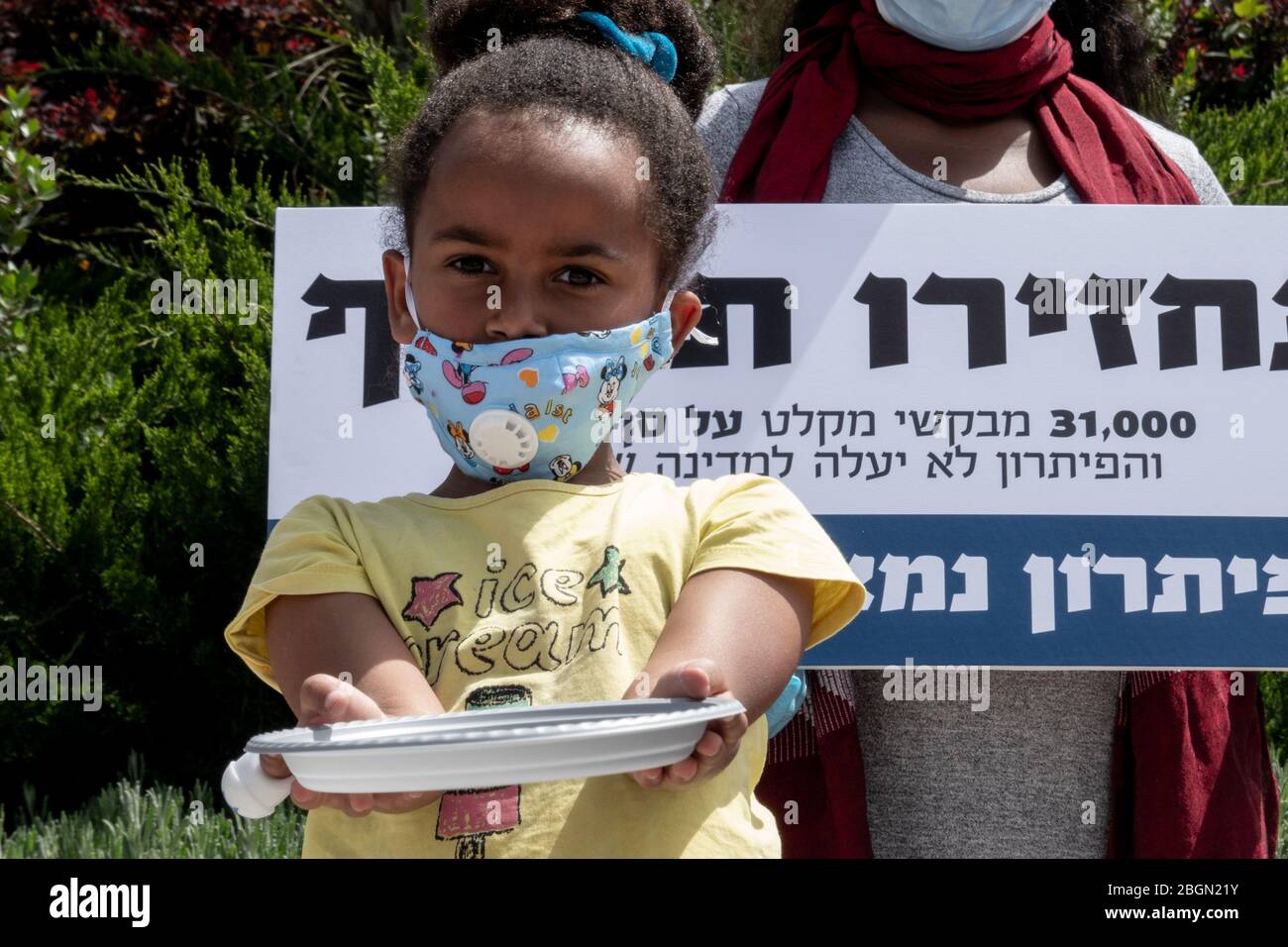 Gerusalemme, Israele. 22 aprile 2020. I bambini con piatti vuoti chiedono cibo come richiedenti asilo africani, una comunità di 31,000 persone, fase a ‘Rendete indietro la protesta dei nostri soldi al di fuori del parlamento israeliano che chiede che i salari confiscati dal governo siano immediatamente liberati. Dal 2017 lo Stato ha dedotto il 20% dei salari dei richiedenti asilo depositandoli su conti ritirabili solo dopo aver lasciato il paese o ottenuto lo status legale di rifugiato. La pandemia di Coronavirus li ha lasciati senza reddito e senza assistenza governativa. I richiedenti asilo sostengono che la loro situazione socioeconomica era misera a cominciare con e. Foto Stock