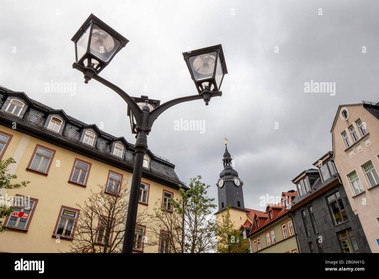 Luci di strada e architettura distintive, insieme a Stadtkirche St. Jakobus sullo sfondo, nella città di Ilmenau, Turingia, Germania Foto Stock