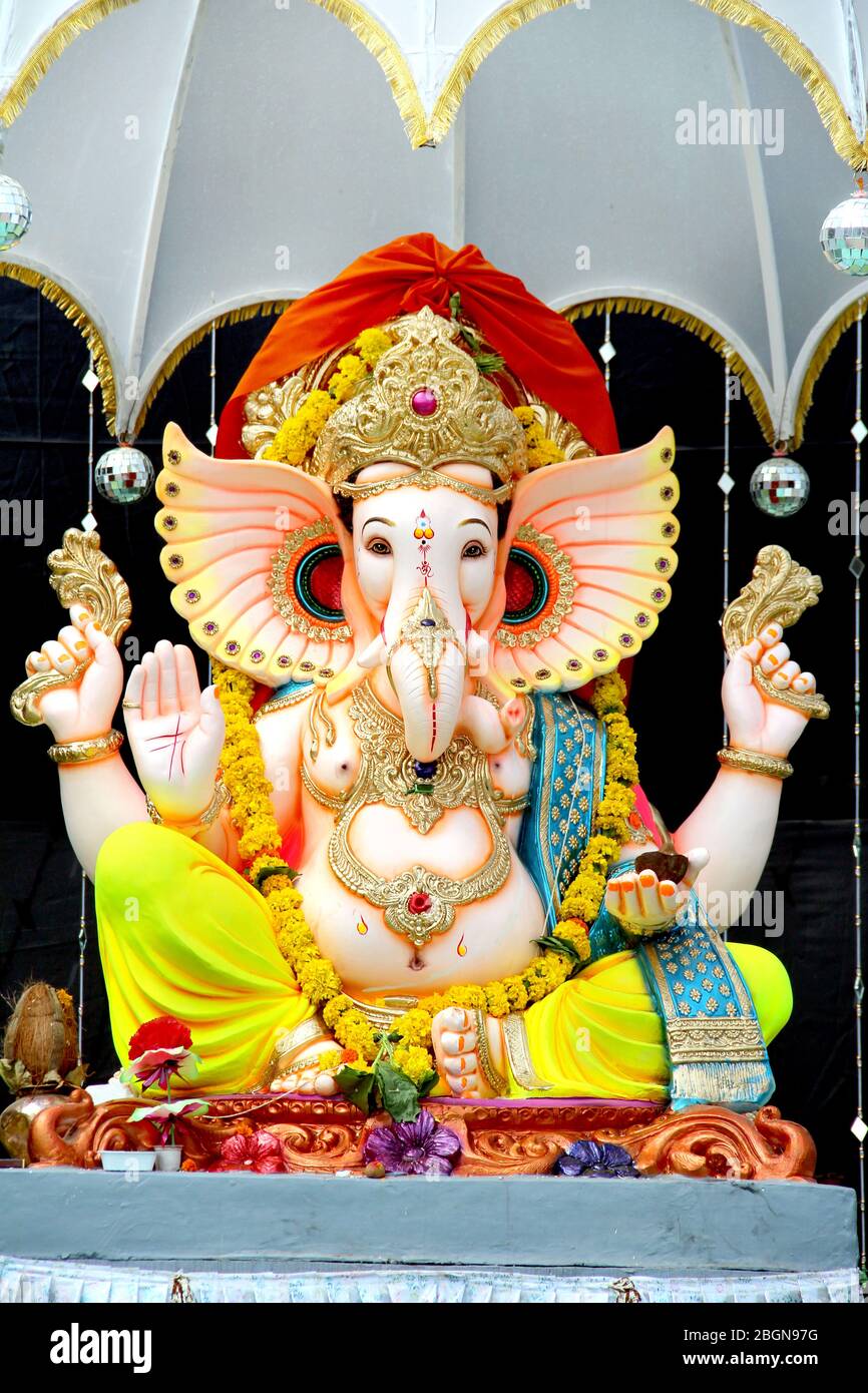 Statua dipinta a mano colorata del Dio indù indiano del Signore Idol Ganesha.Ganpati fatto di pietra di argilla di fango di terra o roccia per il culto Pooja in profondità Foto Stock