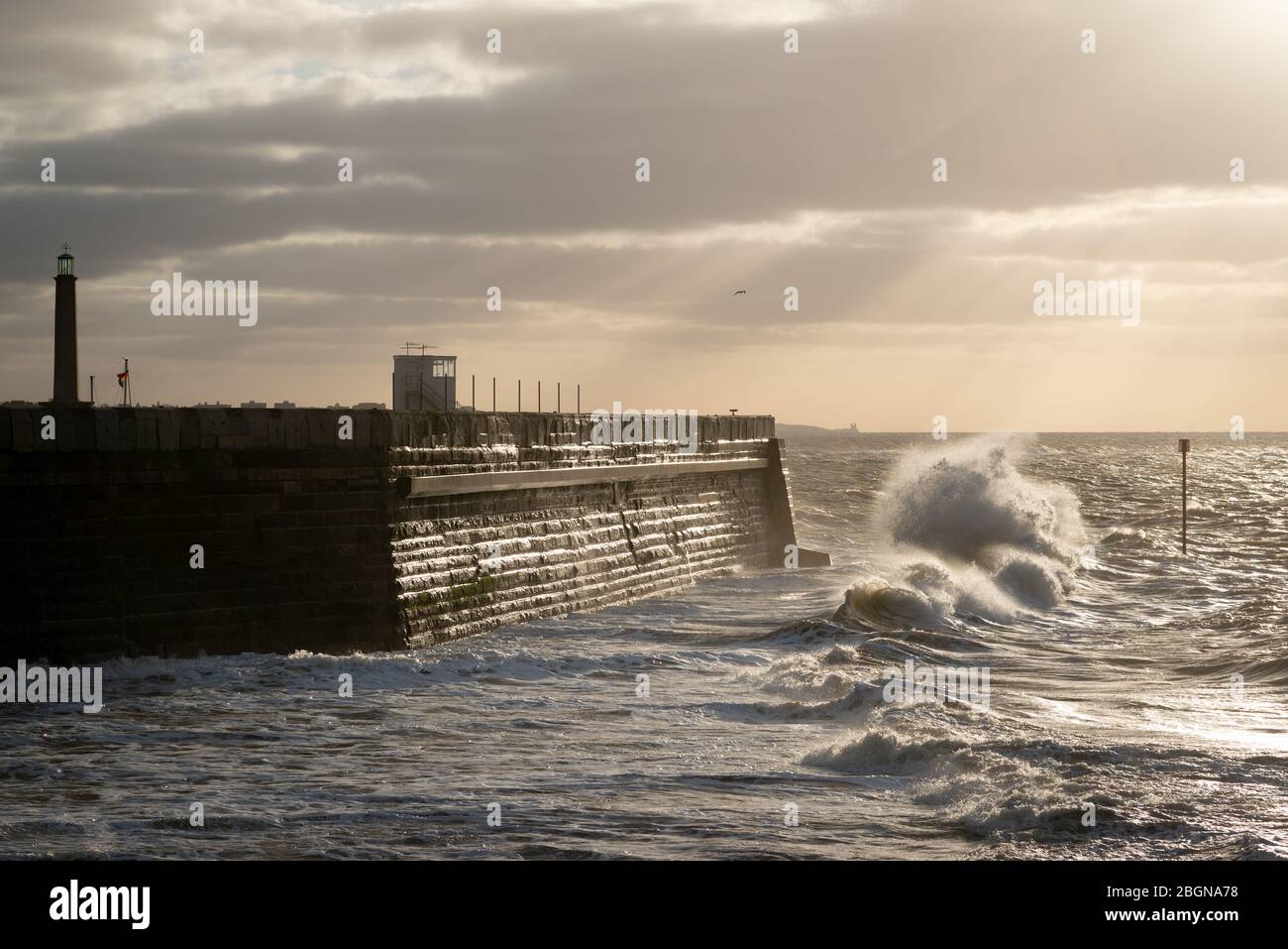 Il tempo è tempestoso e le onde si infrangono sul braccio del porto di Margate, Kent Foto Stock