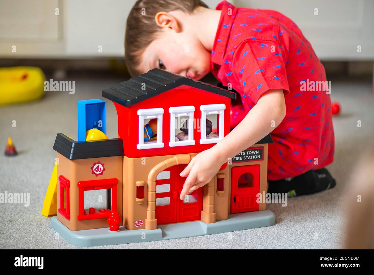 Un ragazzo gioca con una stazione di fuoco giocattolo Foto Stock