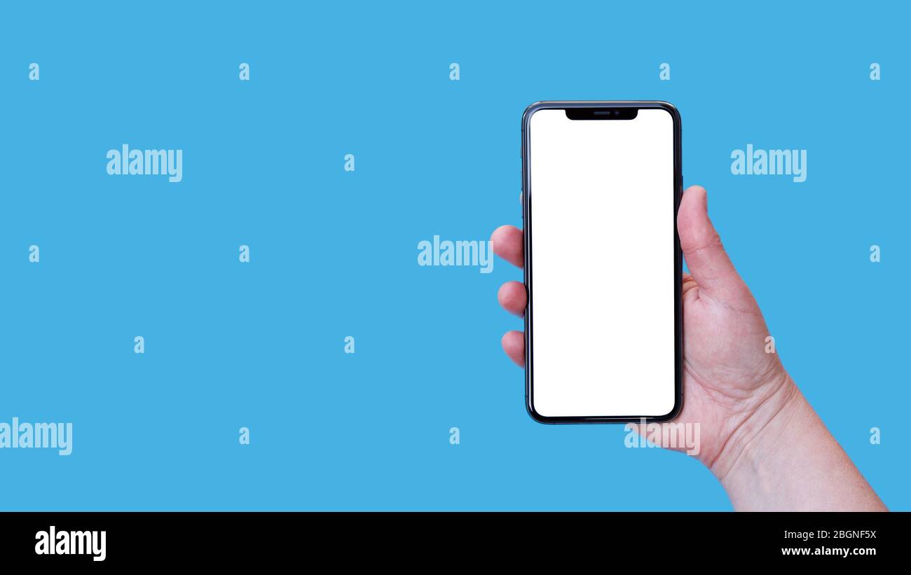 Smartphone moderno con schermo vuoto a mano femminile isolato su sfondo blu. Foto Stock
