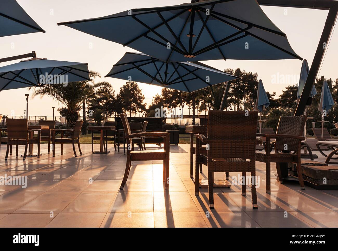 Mare all'aperto vuoto caffè con belle silhouette nel tramonto luce del sole. Concetto di vacanza. Foto Stock