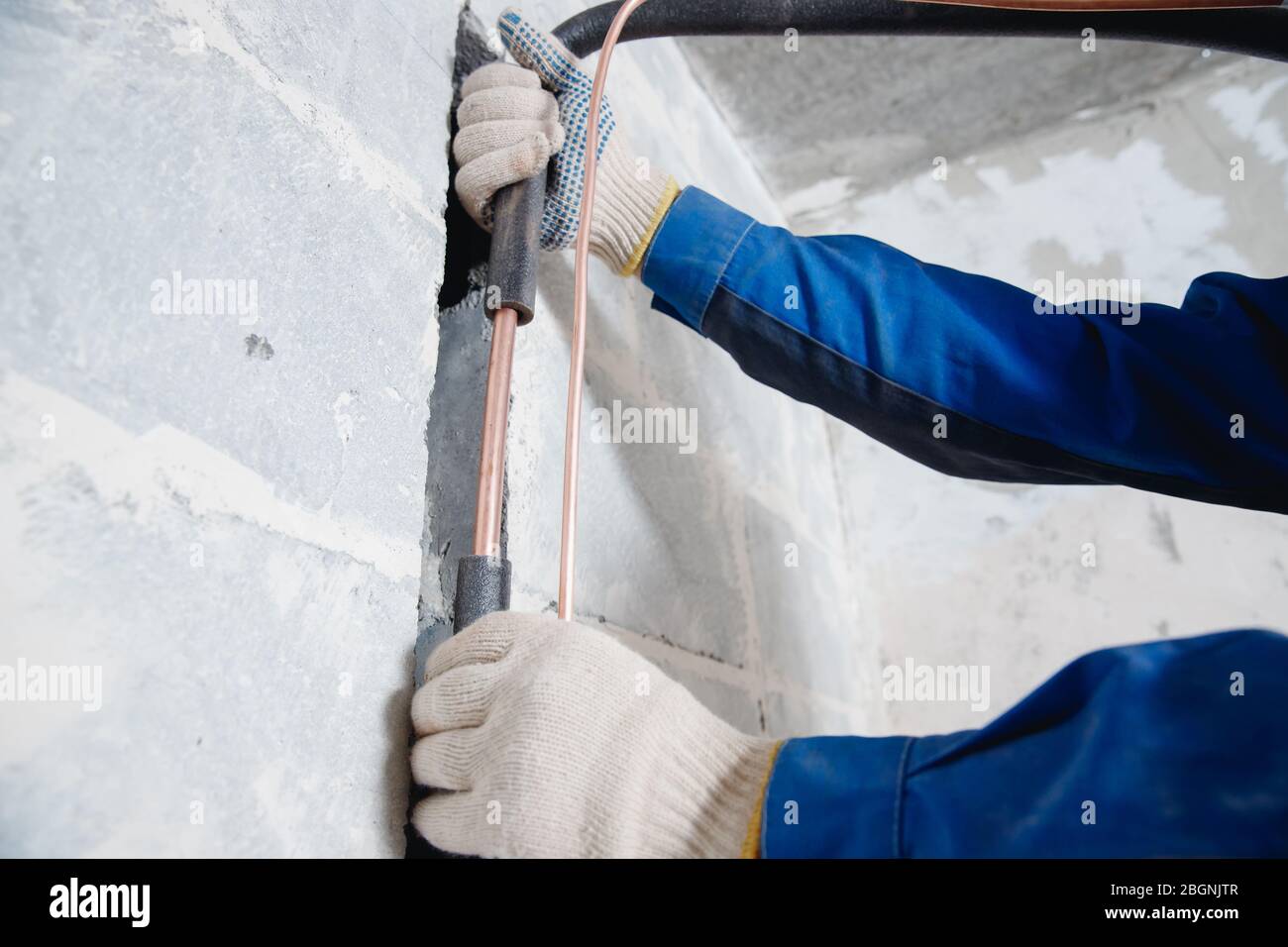 Installazione di canaletto per il collegamento del condizionatore d'aria in calcestruzzo Foto Stock