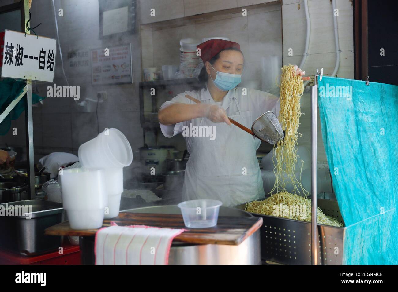 Wuhan, provincia cinese di Hubei. 22 aprile 2020. Uno chef prepara tagliatelle calde secche, una sorta di popolare colazione locale, presso un ristorante di tagliatelle calde secche in Liangdao Street di Wuhan, nella provincia di Hubei della Cina centrale, il 22 aprile 2020. Con la sua riduzione dell'epidemia di COVID-19, molti negozi di prima colazione a Wuhan hanno riaperto la loro attività per offrire colazioni preparate al momento ai residenti in base a misure di prevenzione e controllo epidemiche. Credit: Shen Bohan/Xinhua/Alamy Live News Foto Stock