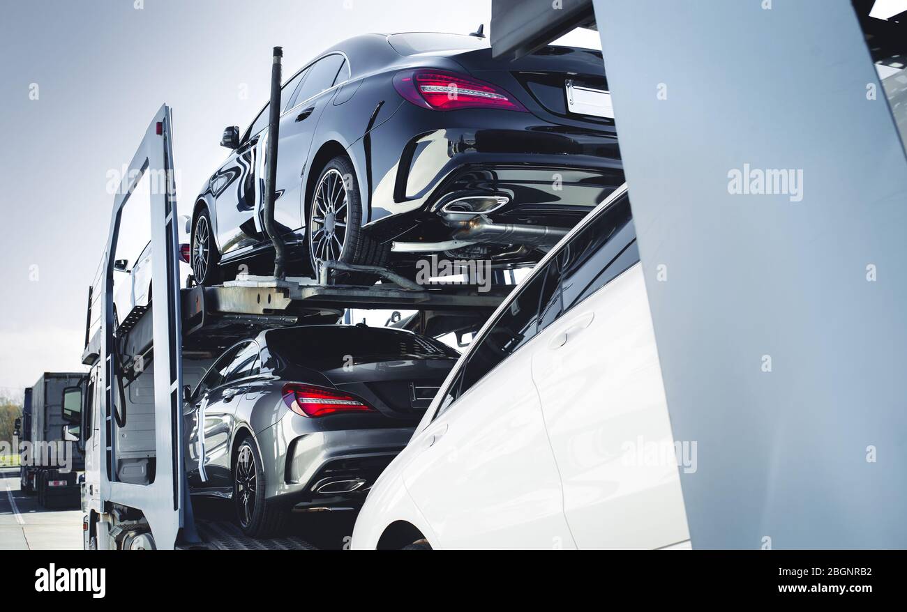 Camion grande di auto trasportatrice di nuovo lusso sport auto tedesche consegna al concessionario. Camion di nuovi veicoli nuovi potenti. Dettaglio auto : rivestimento in vetro Au Foto Stock