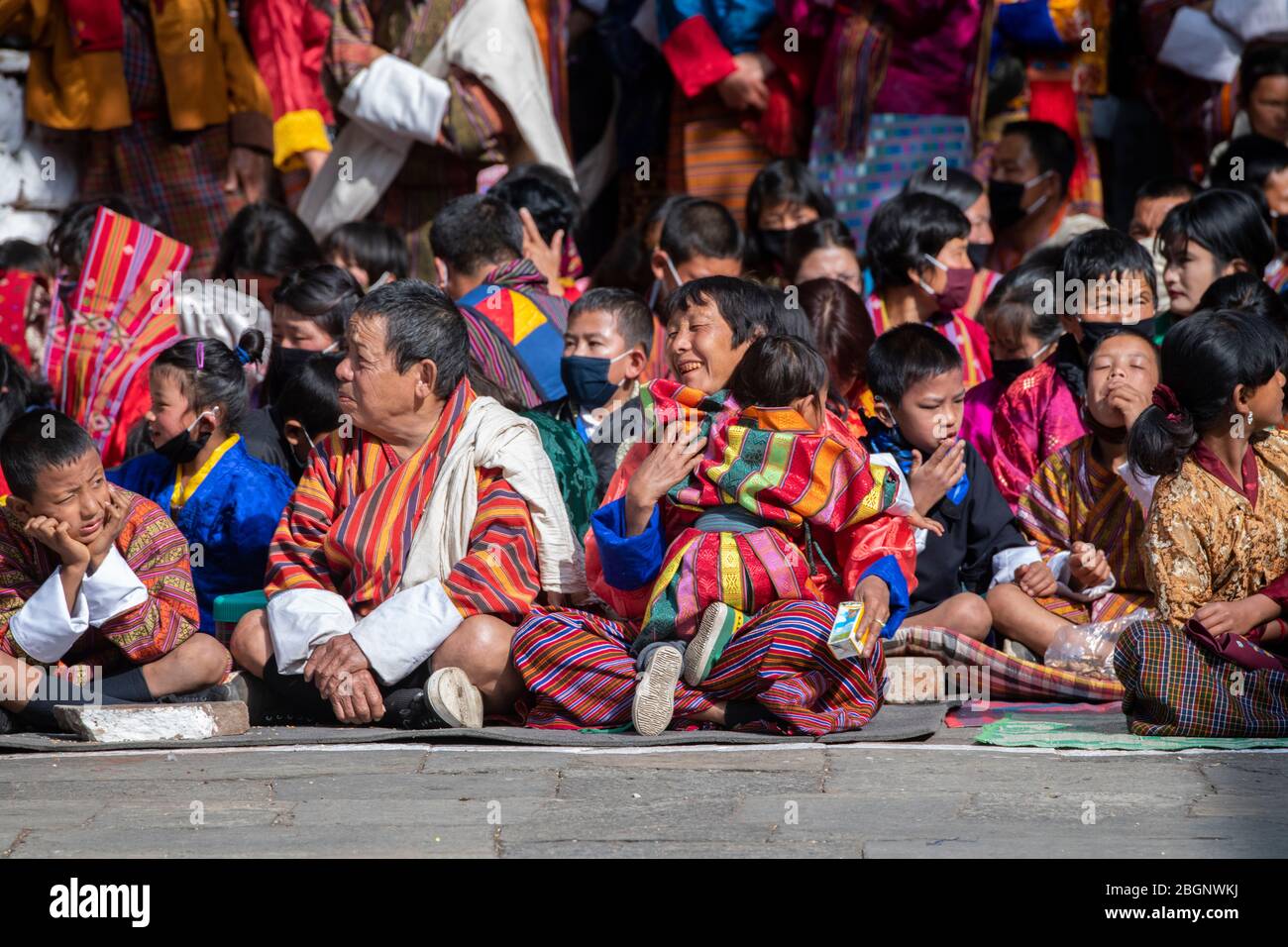 Bhutan, Punakha Dzong. Punakha, Druchen Festival. Famiglie locali in tradizionale abbigliamento festival di osservazione. Foto Stock