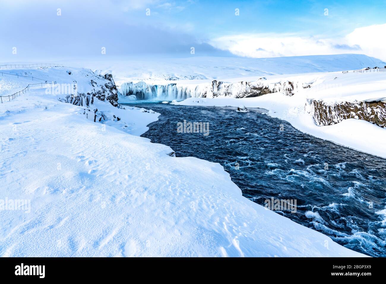 Il fiume islandese ghiacciato a metà Skjalfandafljot scorre sulla cascata Godafoss in inverno. Ancora in forte scorrimento ma neve coperta e con grande icic Foto Stock