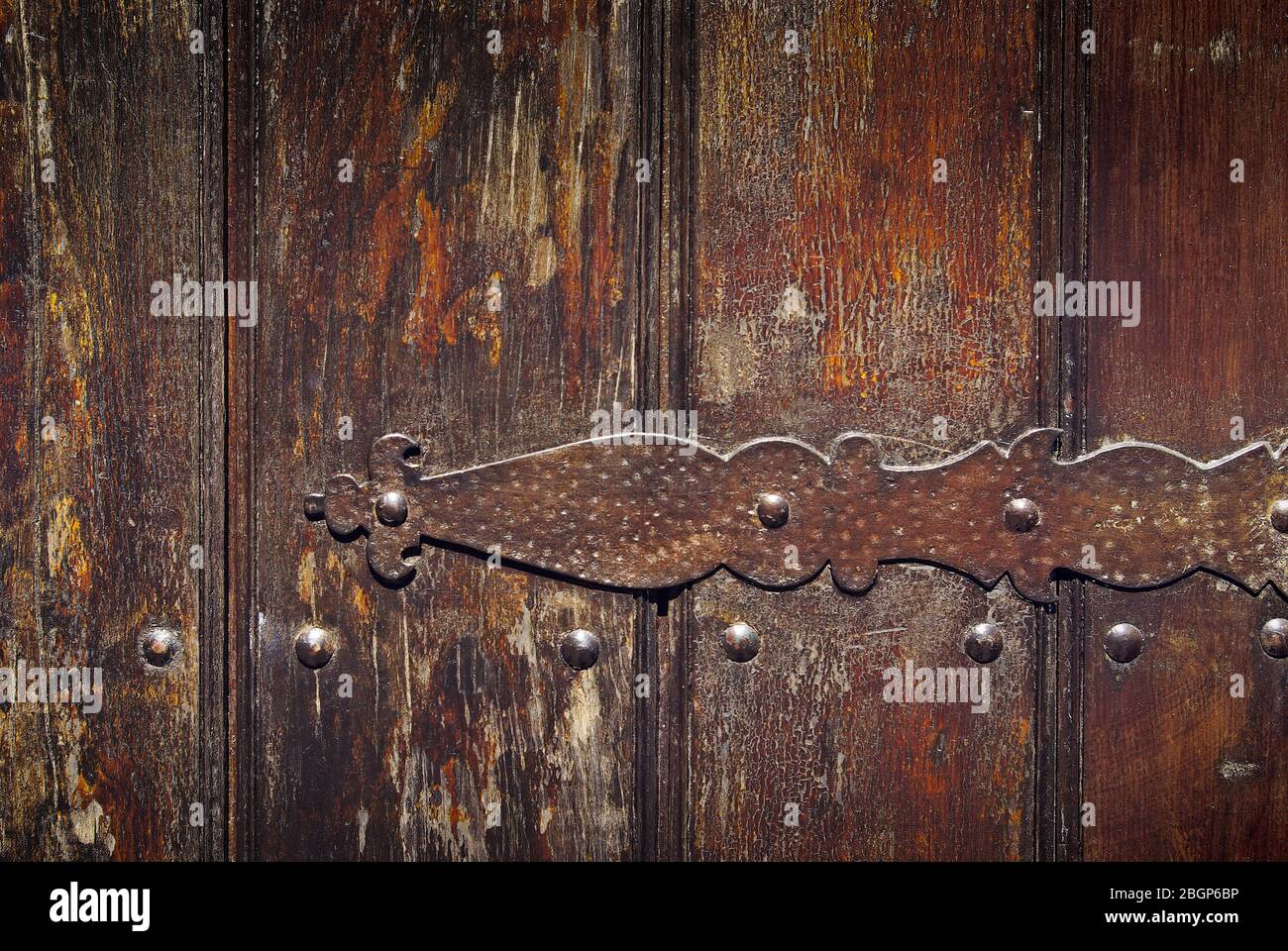 Particolare di una vecchia cerniera in ferro arrugginito su una porta di legno Foto Stock