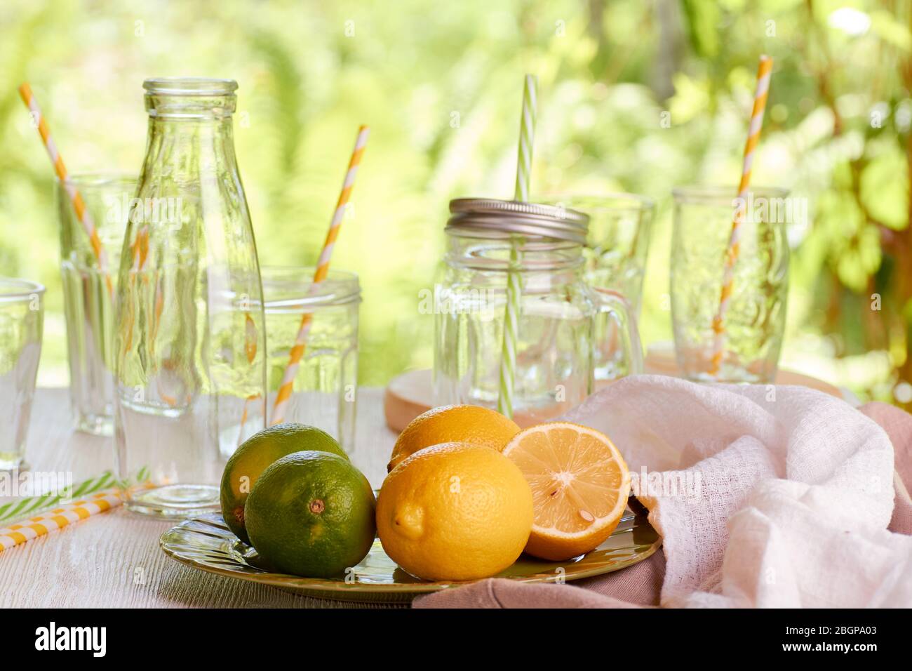 Lime e limoni per la preparazione di bevande estive. Sfondo di sole Foto Stock