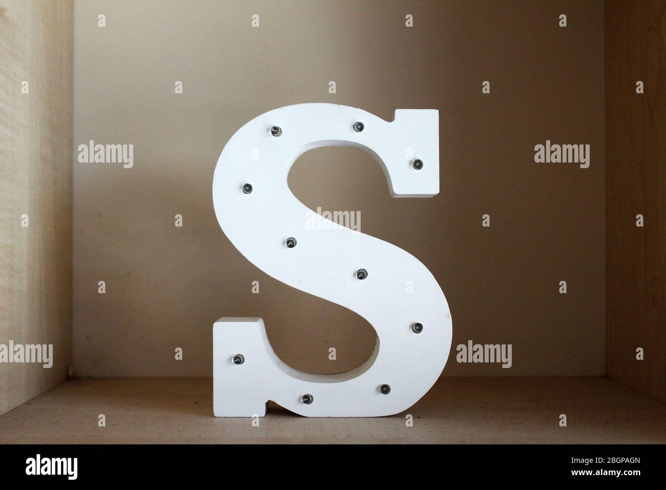 Lettera grande e decorativa 'S' su uno scaffale Foto Stock