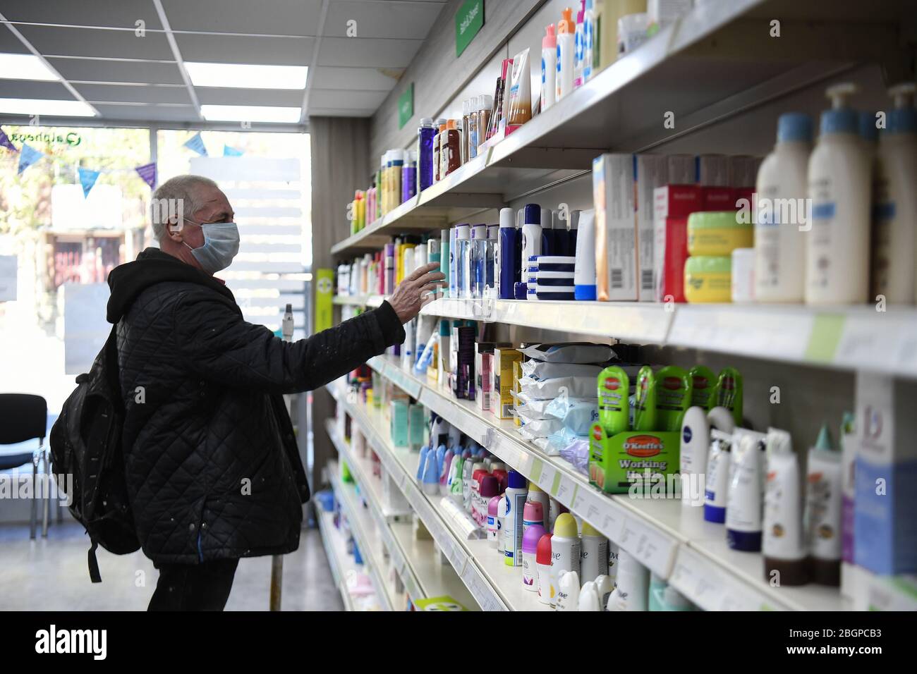 Un cliente della Copes Pharmacy di Streatham, mentre il Regno Unito continua a bloccare per contribuire a frenare la diffusione del coronavirus. Foto Stock