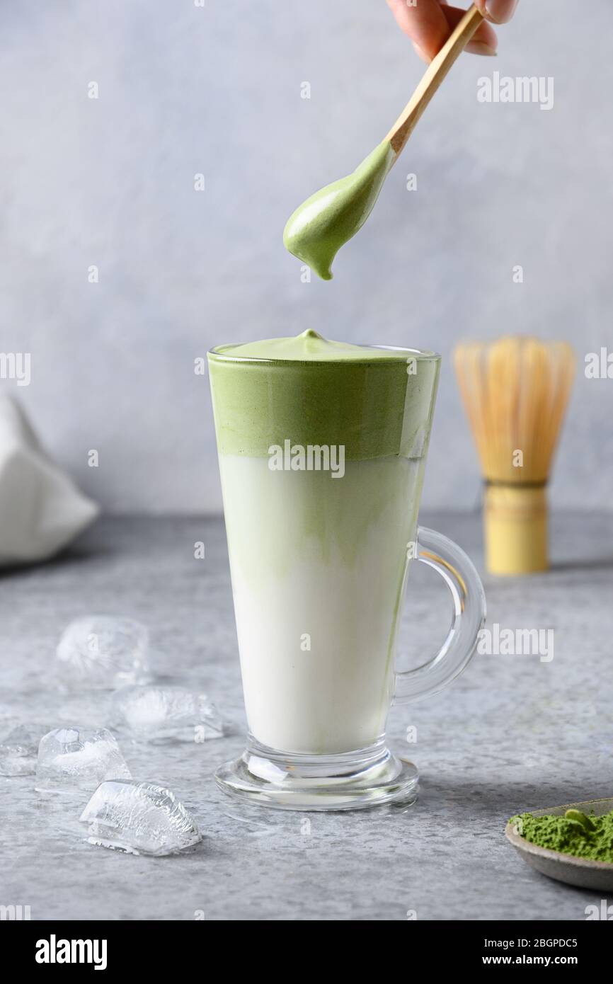 Dalgona Iced Matcha tè con tè montato e latte freddo. Gustosa bevanda virale nel tempo autoisolamento. Formato verticale. Foto Stock
