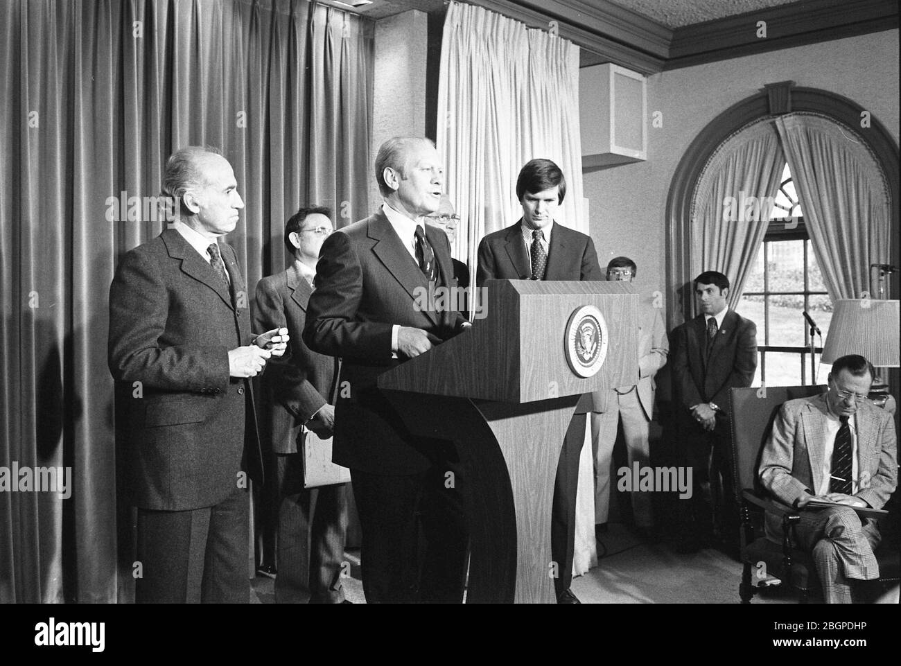 Il presidente Gerald R Ford, accompagnato dal Dr. Jonas Salk (a sinistra) e dal Segretario del Dipartimento di Salute, Istruzione e benessere F. David Mathews (a destra), annuncia il programma nazionale di immunizzazione dell'influenza suina nella sala stampa briefing, Washington, DC, 03/24/1976. Foto di Ricardo Thomas/Gerald R Ford Library Foto Stock