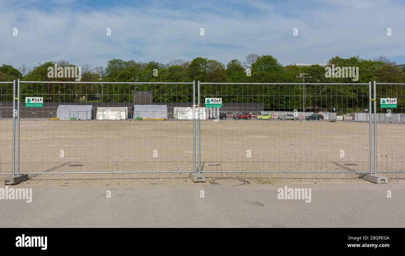 Panorama (16x9) di Coronavirus Drive-in a Theresienwiese. Diverse tende bianche con auto in fila. Dietro una recinzione. Cielo blu. Foto Stock