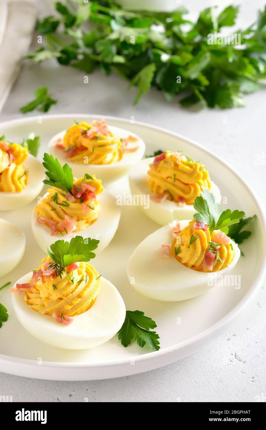 Divared uova farcite con tuorlo d'uovo, pancetta, senape e prezzemolo, vista ravvicinata Foto Stock