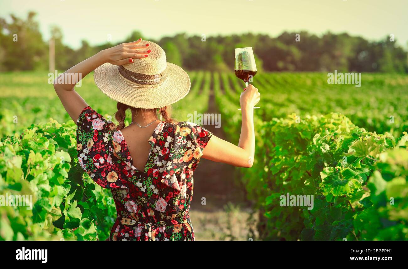 Donna asiatica bere vino rosso in vigna durante le sue vacanze, stile vintage Foto Stock
