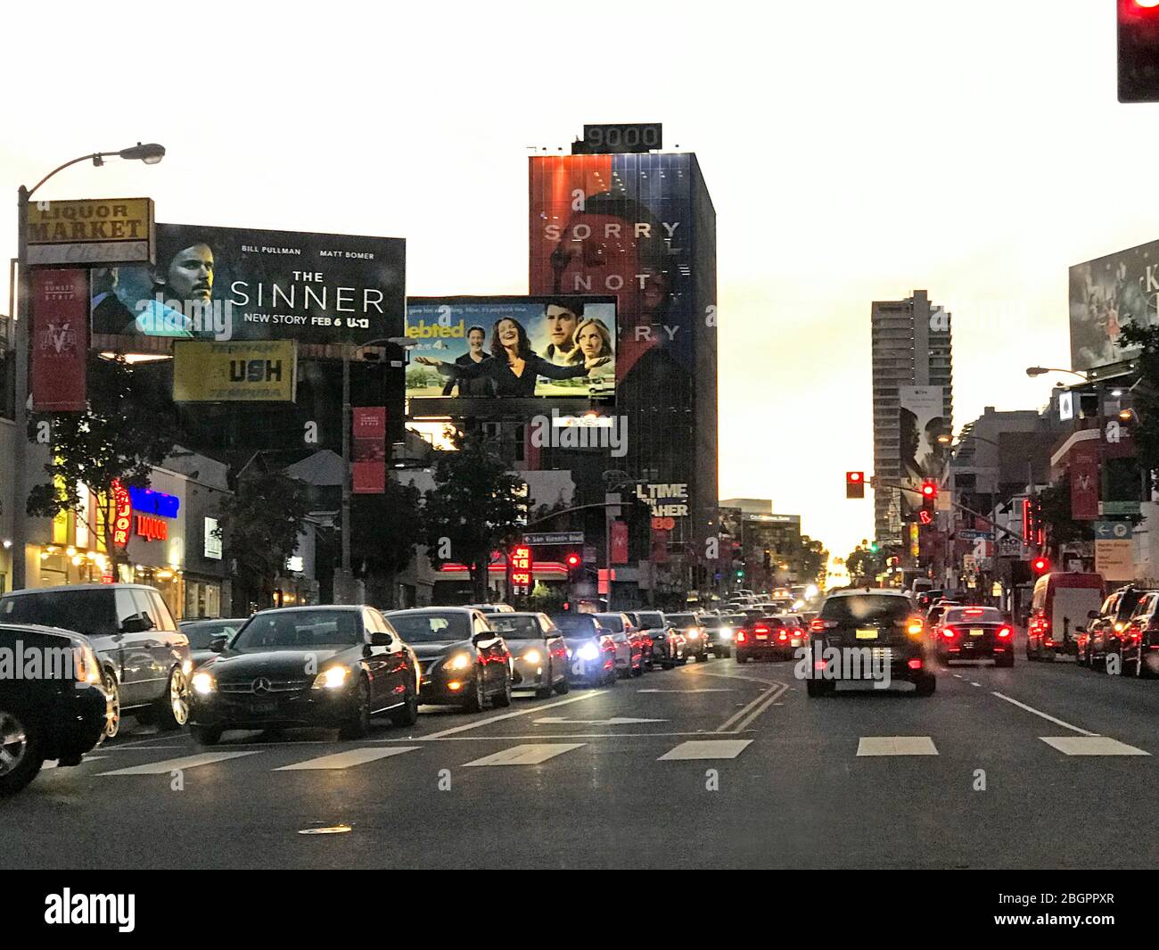 Guida sulla Sunset Strip di notte con affissioni che promuovono film e intrattenimento televisivo a Los Angeles, California Foto Stock