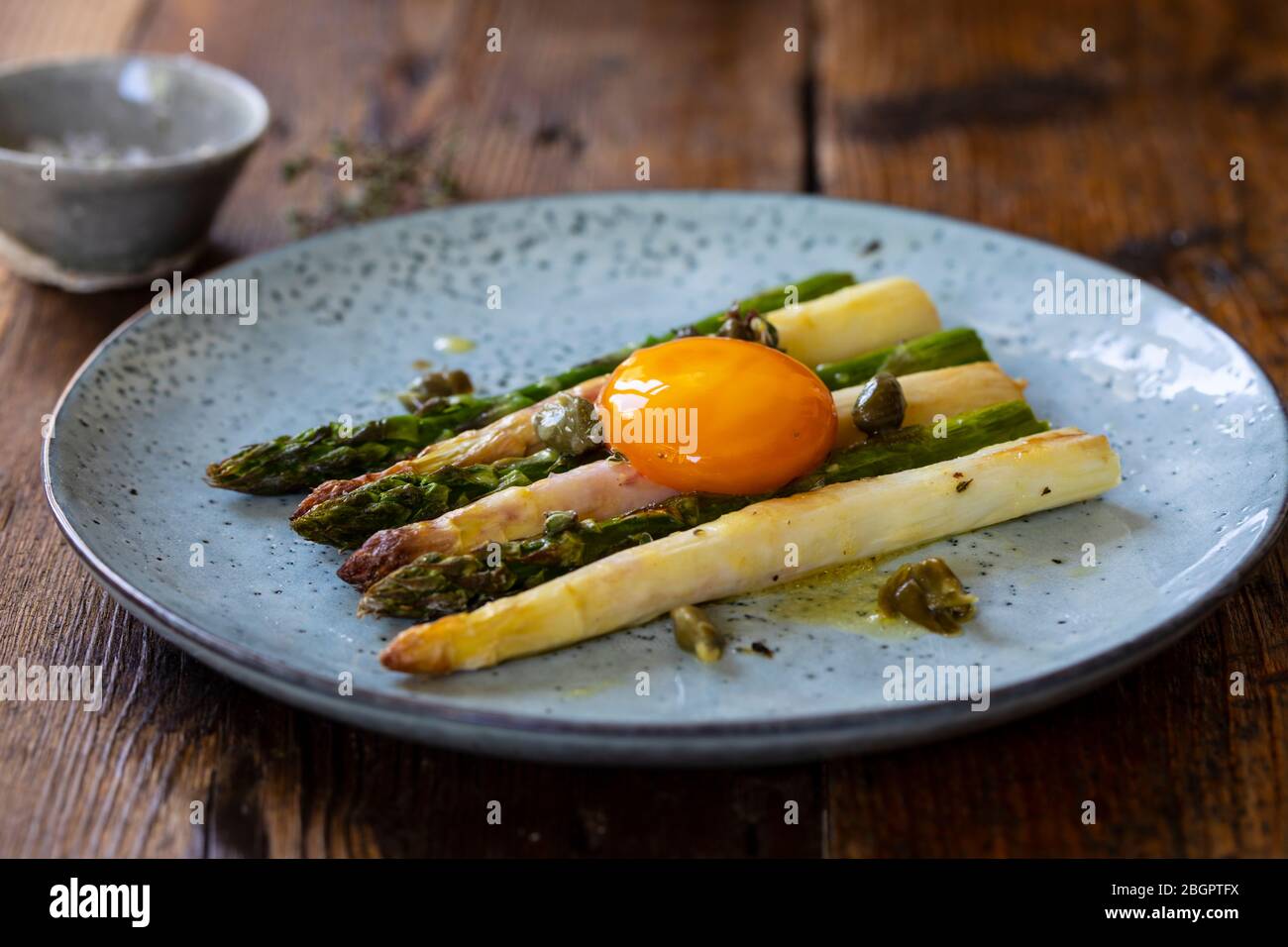 Aspatago bianco e verde arrosto con capperi e condimento di senape e tuorlo d'uovo stagionato Foto Stock