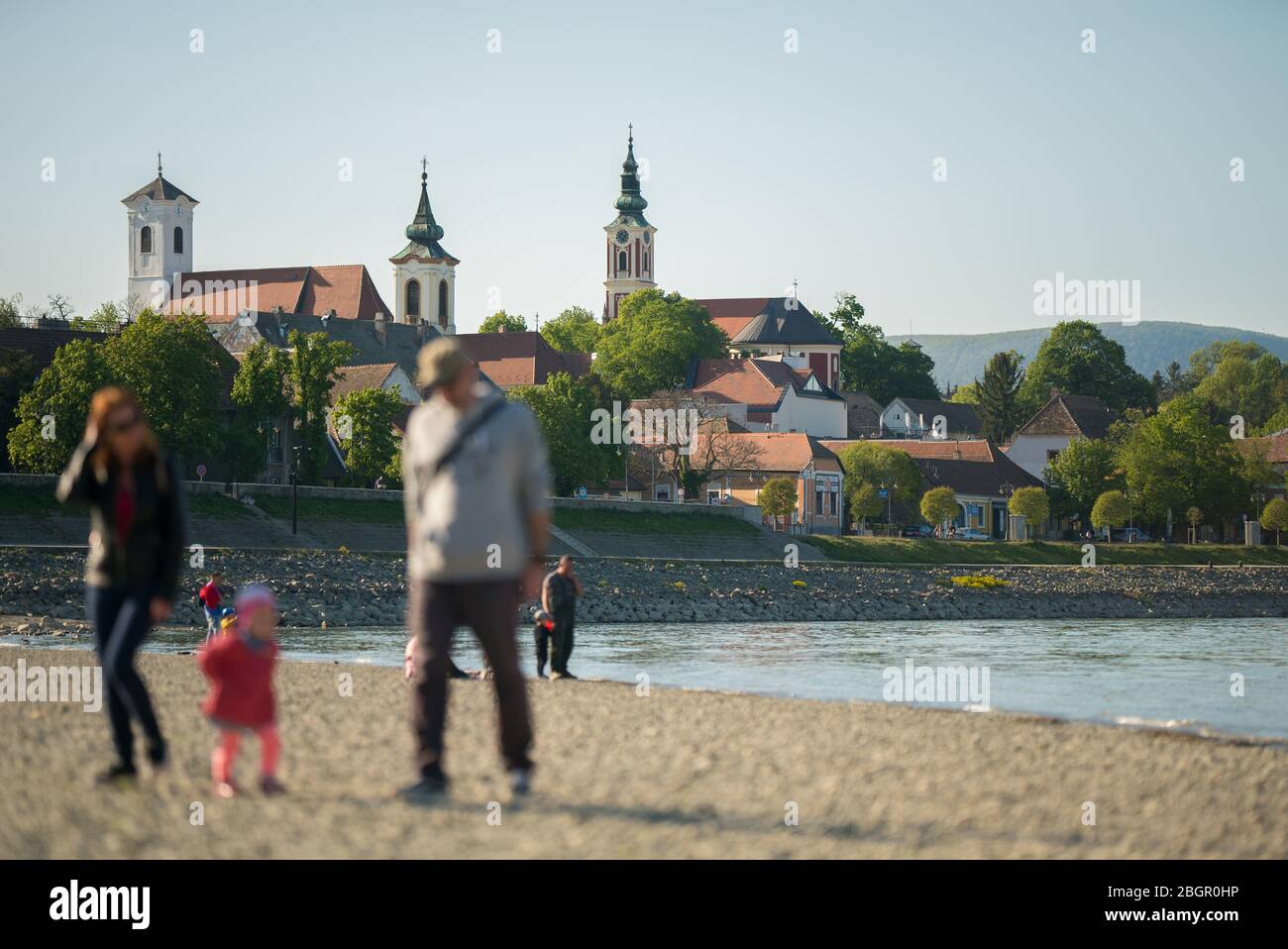 Passeggiata familiare irriconoscibile sulle rive del Danubio a Szentendre, Ungheria. Sullo sfondo si può vedere la città. Foto Stock