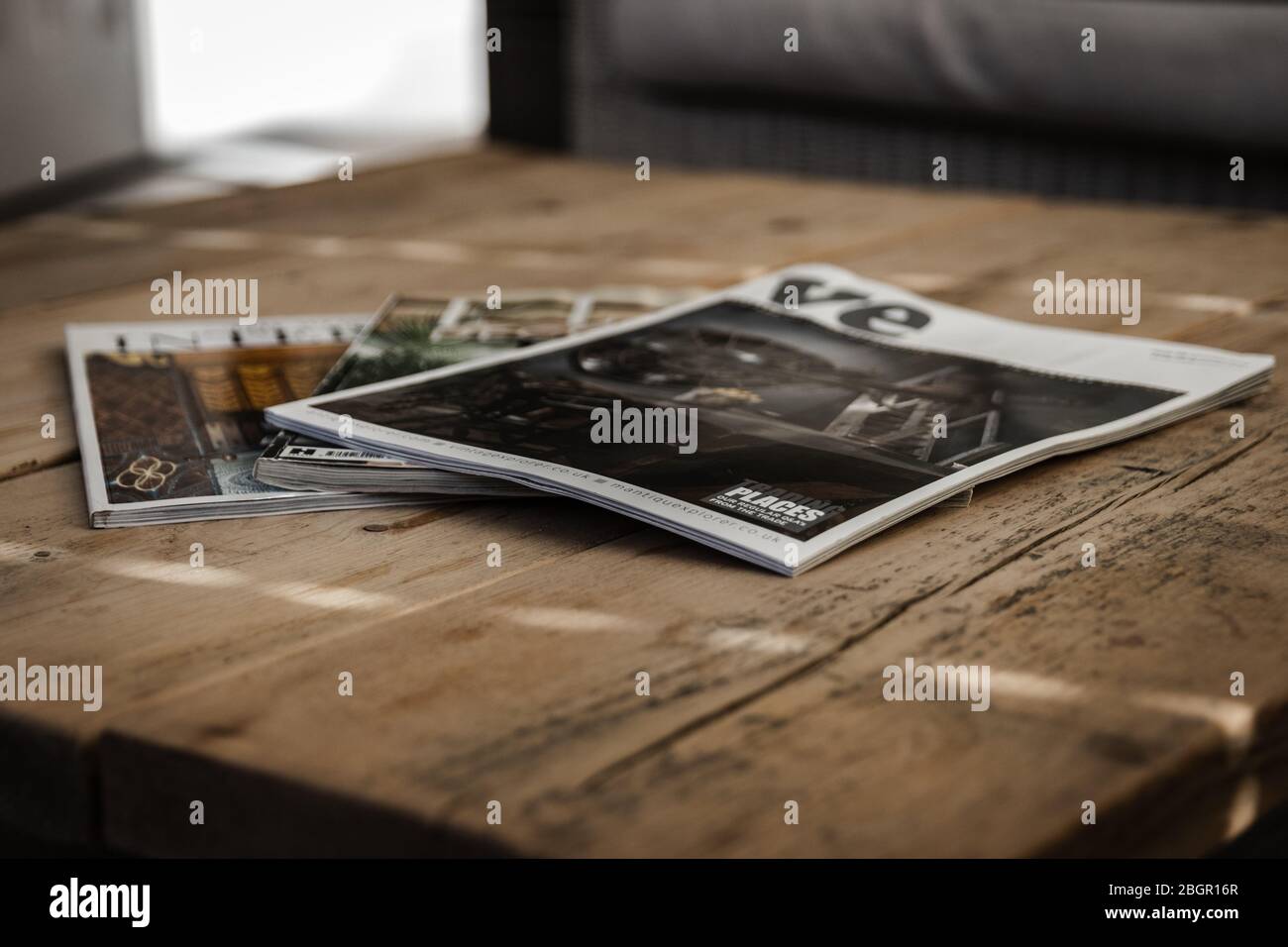 Una pila di riviste disposte su un tavolino di legno Foto Stock