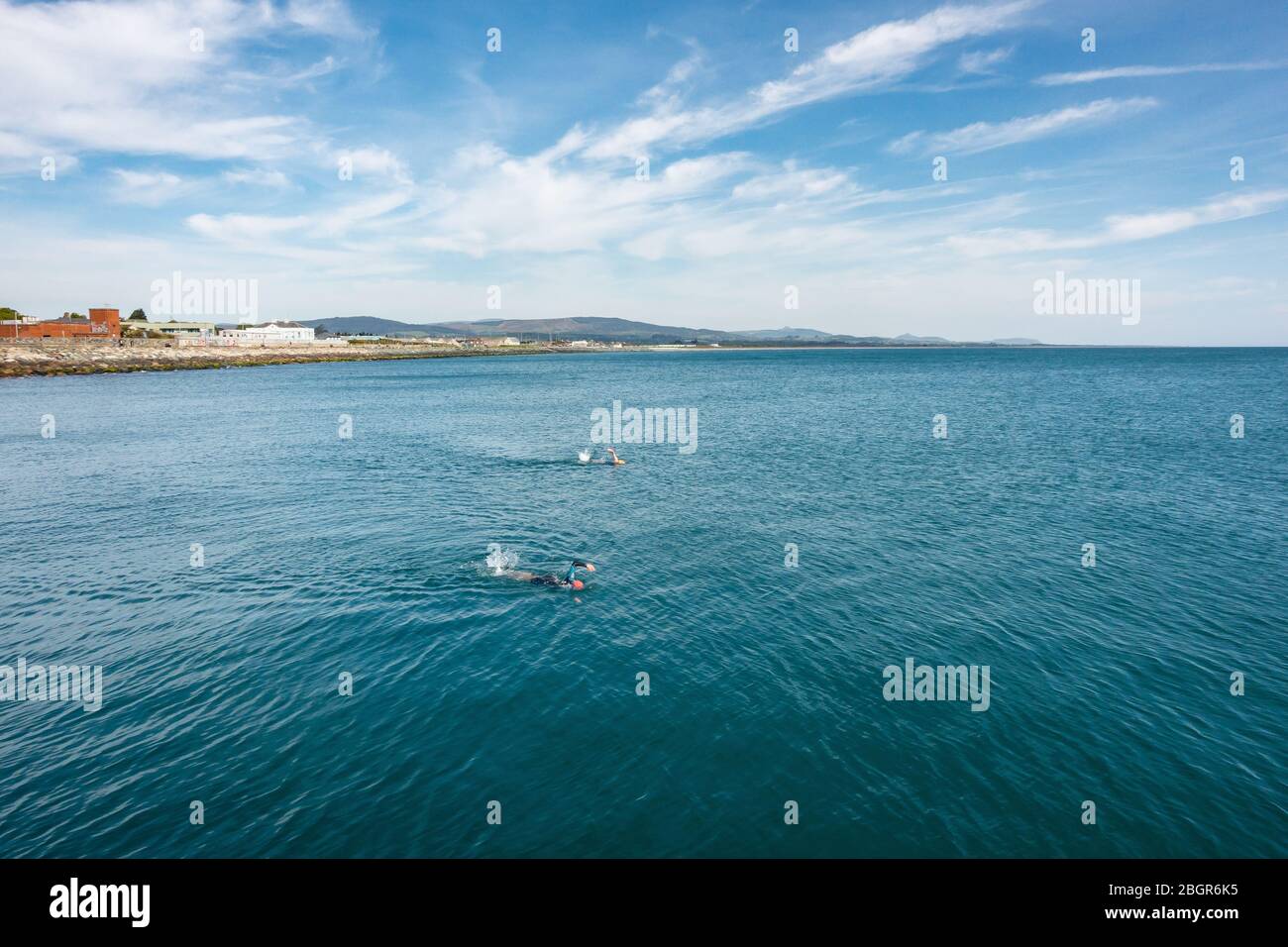 Nuotatori in mare con sfondo paesaggistico Foto Stock