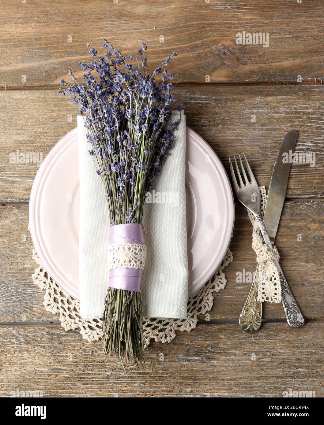 Tavolo da pranzo impostazione con fiori di lavanda sul tavolo di legno sfondo Foto Stock