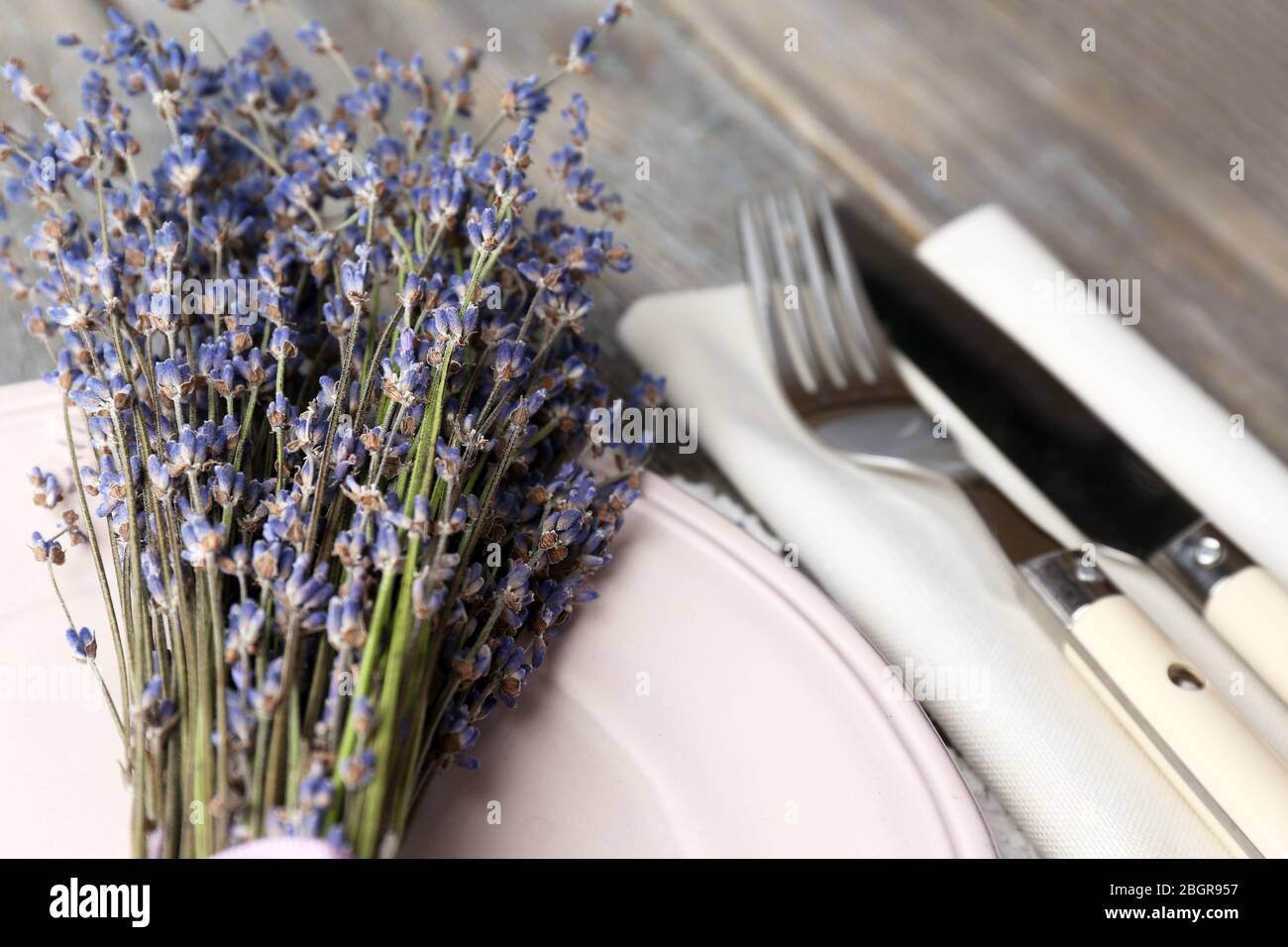 Tavolo da pranzo impostazione con fiori di lavanda sul tavolo di legno sfondo Foto Stock